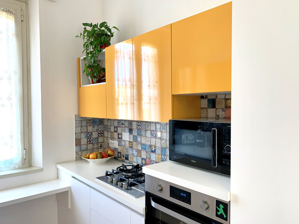 Idée de décoration pour une petite arrière-cuisine parallèle avec un évier 2 bacs, des portes de placard jaunes, une crédence en carreau de ciment, un sol en bois brun et un plan de travail blanc.