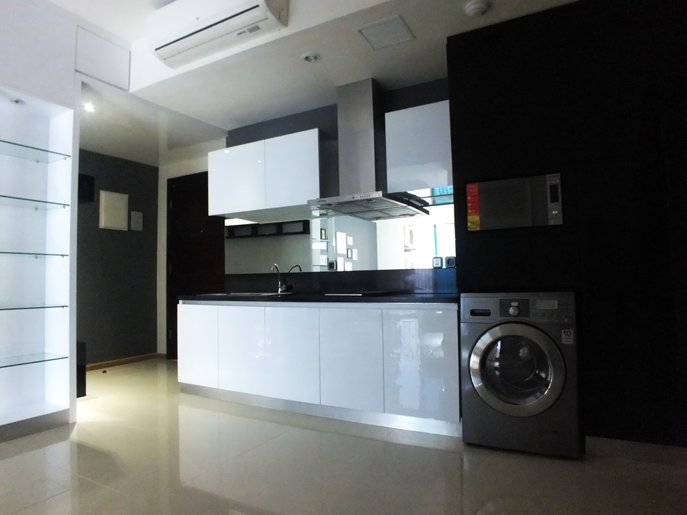 Einzeilige Moderne Wohnküche mit Unterbauwaschbecken, weißen Schränken, Granit-Arbeitsplatte und Küchenrückwand in Schwarz in Sonstige