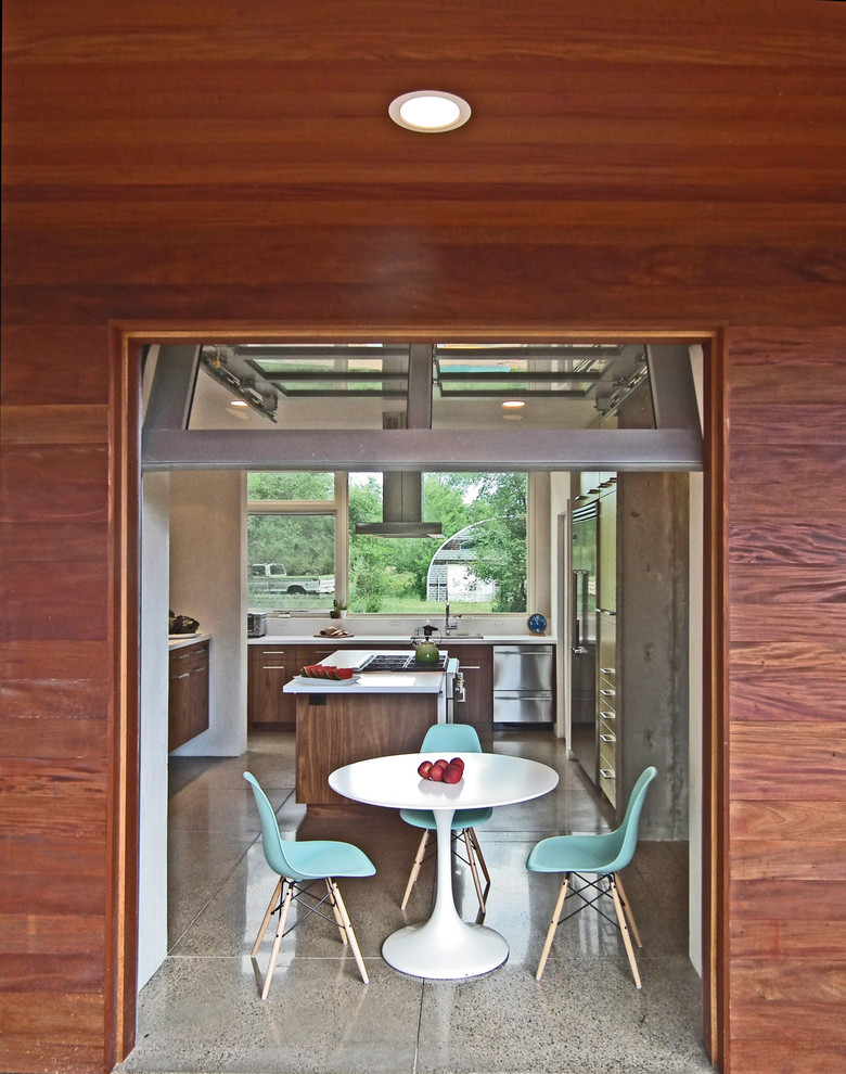 Пример оригинального дизайна: п-образная кухня в стиле модернизм с обеденным столом, плоскими фасадами и темными деревянными фасадами