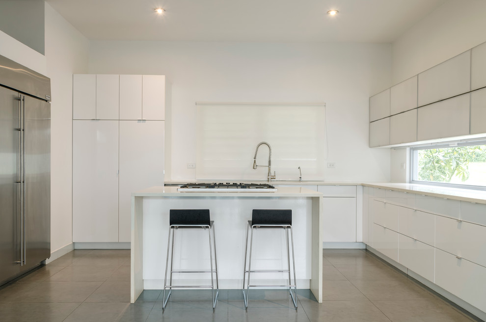Inspiration for a small modern u-shaped enclosed kitchen in Other with a submerged sink, glass-front cabinets, white cabinets, recycled glass countertops, white splashback, white appliances, porcelain flooring and an island.