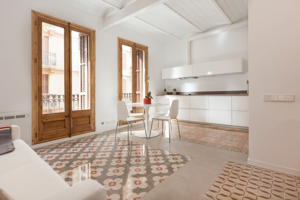 Mittelgroße Moderne Wohnküche ohne Insel in L-Form mit flächenbündigen Schrankfronten, weißen Schränken, Küchenrückwand in Weiß, Küchengeräten aus Edelstahl und Keramikboden in Barcelona