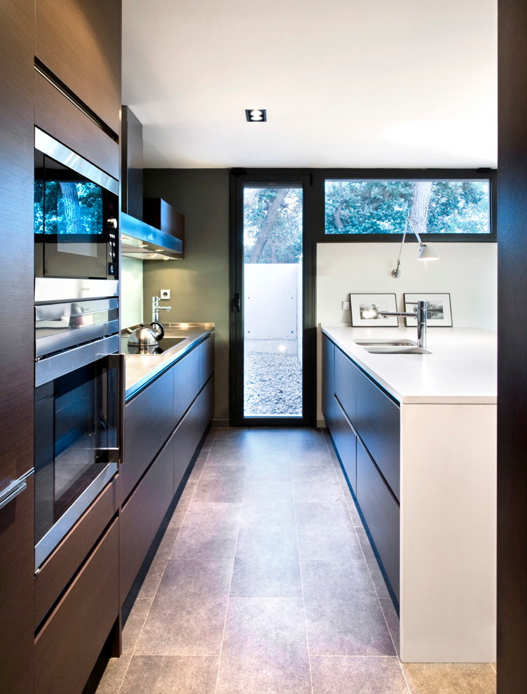 Ejemplo de cocina minimalista con fregadero integrado, puertas de armario de madera en tonos medios y suelo de baldosas de porcelana