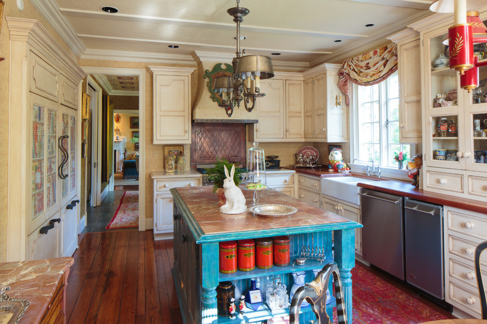 Photo of a mediterranean u-shaped kitchen in Other with a belfast sink, beige cabinets, wood worktops and integrated appliances.