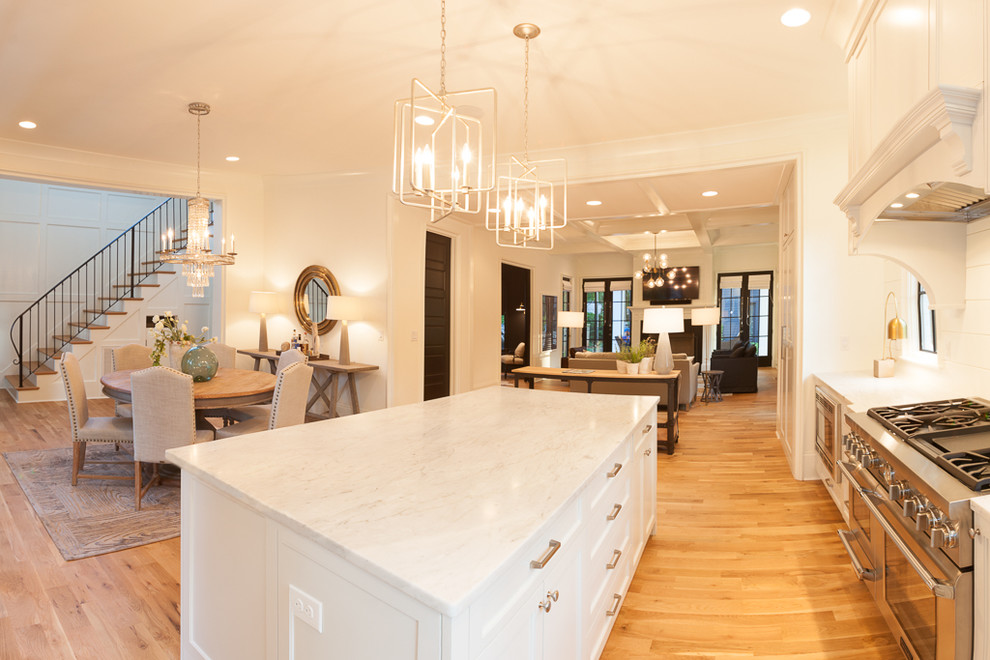 Exempel på ett stort klassiskt l-kök, med vita skåp, marmorbänkskiva, rostfria vitvaror och en köksö