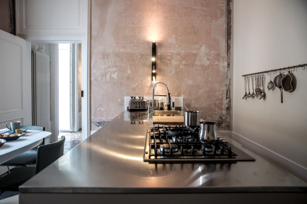 Diseño de cocina comedor abovedada mediterránea con encimera de acero inoxidable, puertas de armario beige, suelo de azulejos de cemento y península
