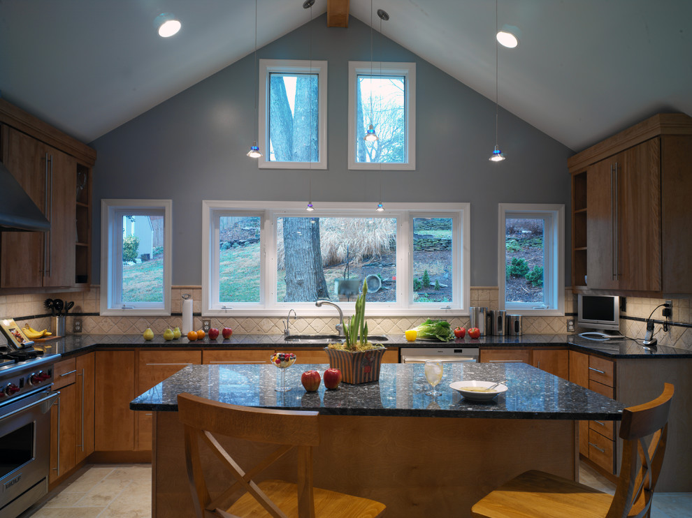 Foto di una cucina minimal con elettrodomestici in acciaio inossidabile, top in granito, lavello sottopiano, ante lisce, ante in legno scuro e paraspruzzi beige