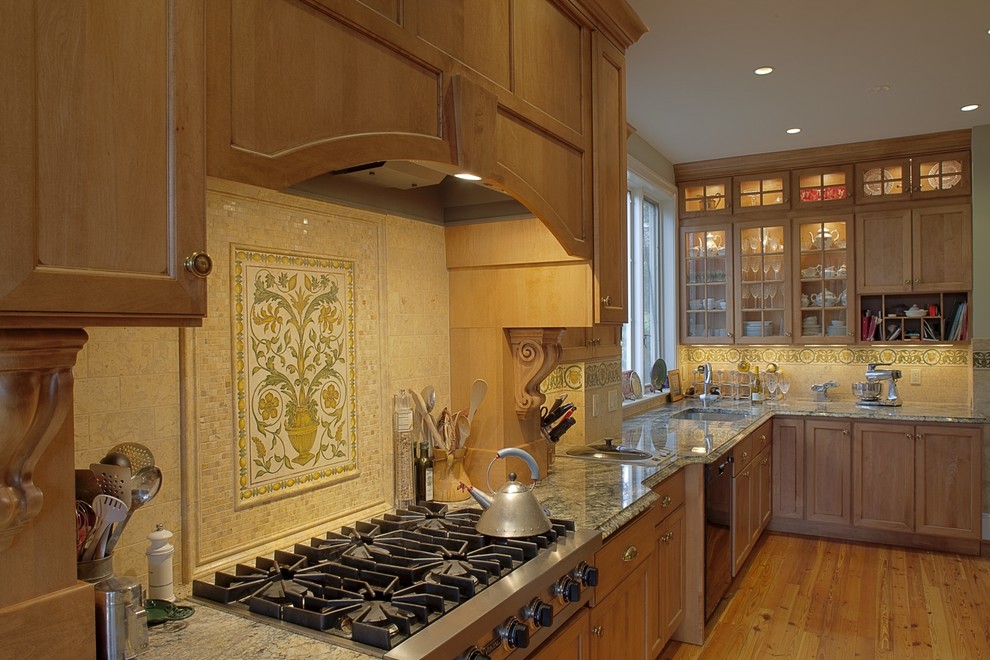ワシントンD.C.にあるトラディショナルスタイルのおしゃれなキッチン (御影石カウンター、アンダーカウンターシンク、落し込みパネル扉のキャビネット、中間色木目調キャビネット、マルチカラーのキッチンパネル) の写真