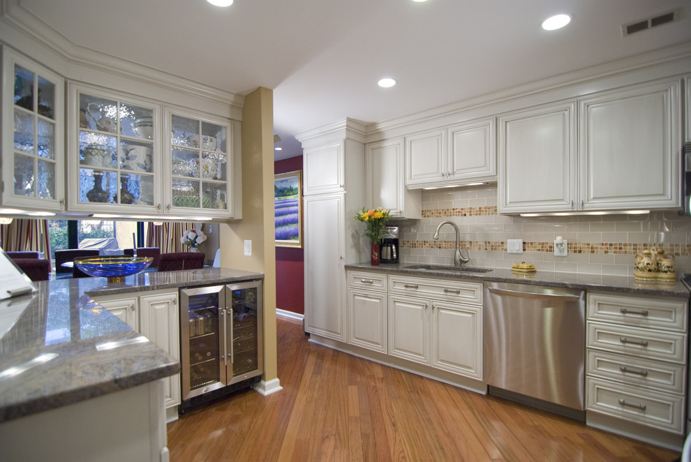 Ejemplo de cocina contemporánea con armarios con paneles con relieve, puertas de armario blancas y electrodomésticos de acero inoxidable