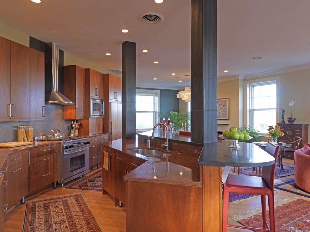 Aménagement d'une cuisine ouverte encastrable classique en bois brun avec un plan de travail en granite, un évier encastré et un placard à porte plane.