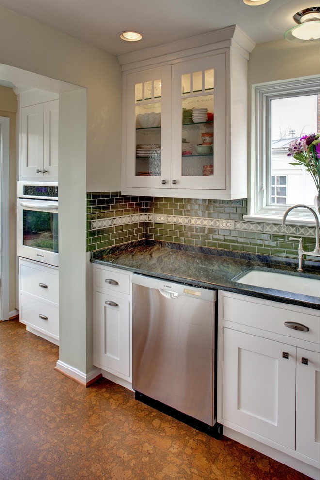 Traditional kitchen in DC Metro with glass-front cabinets, a submerged sink, white cabinets, granite worktops, green splashback, metro tiled splashback and stainless steel appliances.