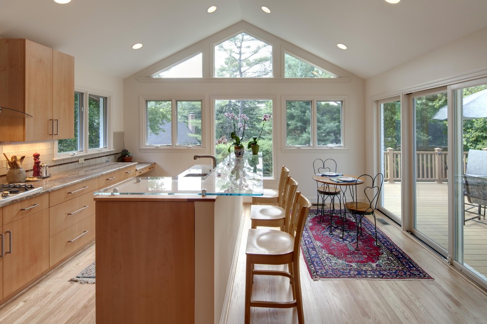 ワシントンD.C.にあるコンテンポラリースタイルのおしゃれなキッチン (ガラスカウンター、フラットパネル扉のキャビネット、中間色木目調キャビネット、白いキッチンパネル、サブウェイタイルのキッチンパネル) の写真