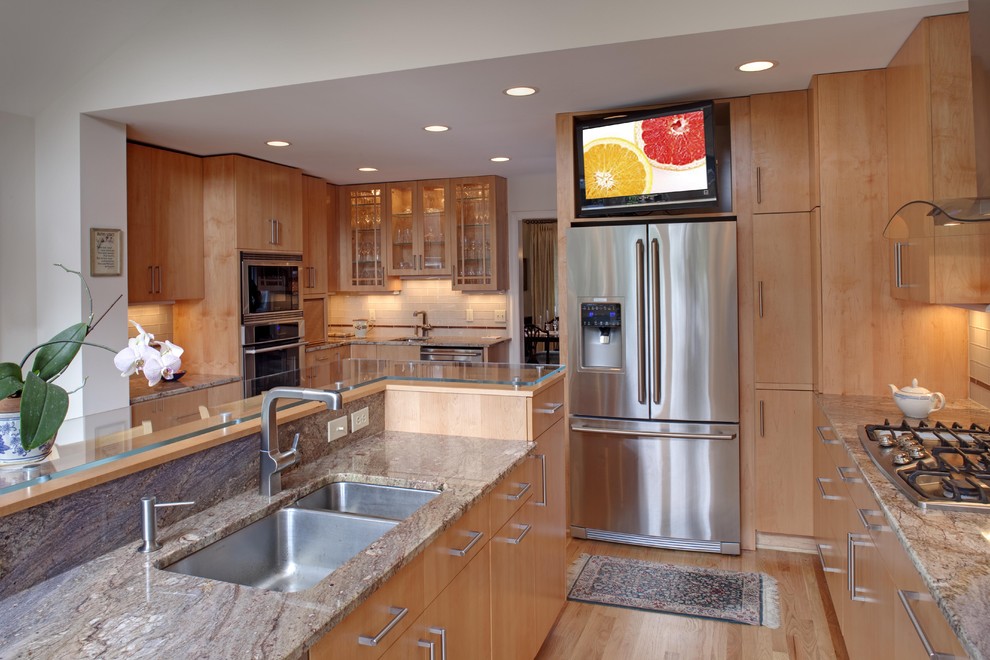 Example of a trendy kitchen design in DC Metro with flat-panel cabinets, stainless steel appliances, granite countertops, a double-bowl sink and medium tone wood cabinets