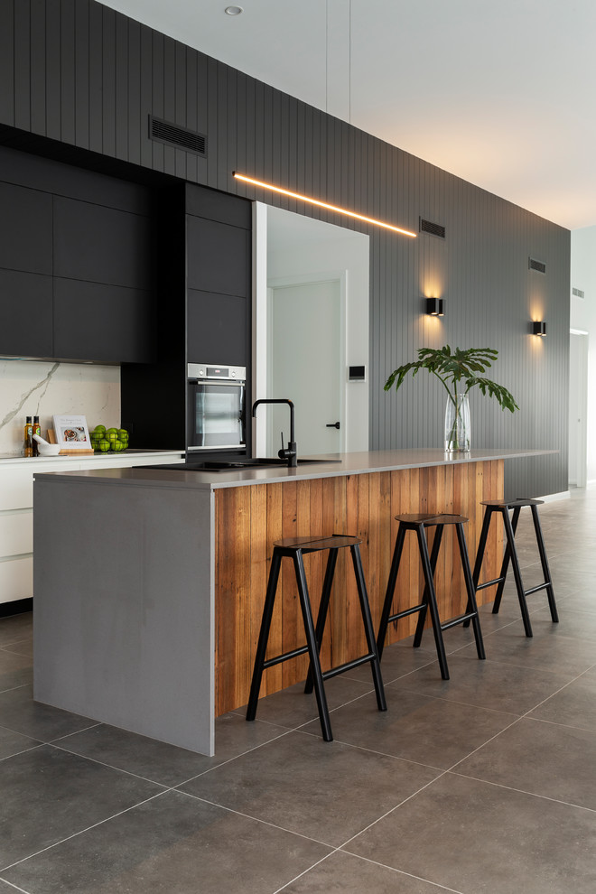 Große Moderne Küche mit schwarzen Schränken, Quarzwerkstein-Arbeitsplatte, Küchenrückwand in Weiß, Rückwand aus Porzellanfliesen, schwarzen Elektrogeräten und zwei Kücheninseln in Canberra - Queanbeyan