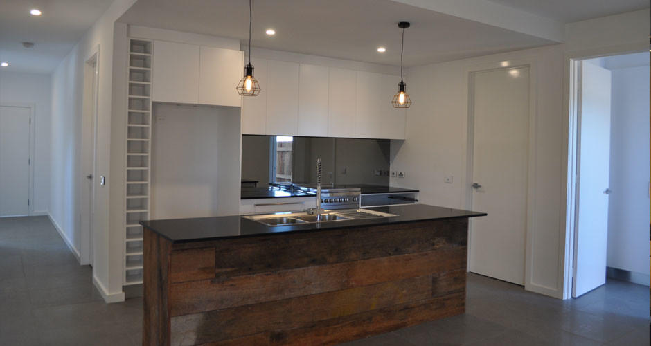 This is an example of a medium sized urban galley kitchen/diner in Canberra - Queanbeyan with a double-bowl sink, flat-panel cabinets, white cabinets, granite worktops, grey splashback, mirror splashback, stainless steel appliances, ceramic flooring and an island.