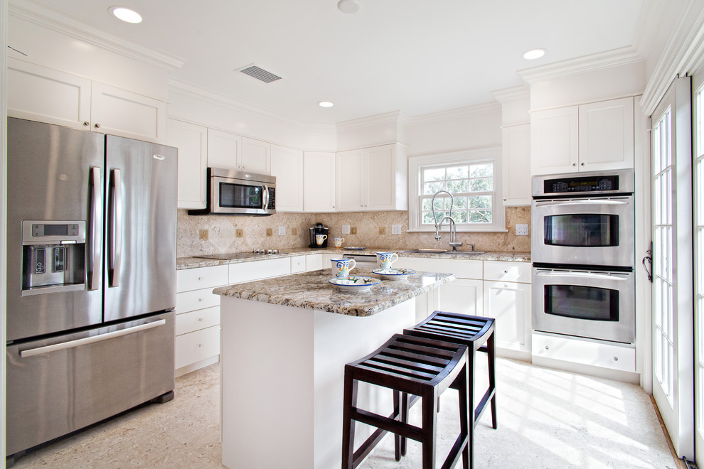 Photo of a traditional l-shaped kitchen in Miami with stainless steel appliances, shaker cabinets and white cabinets.