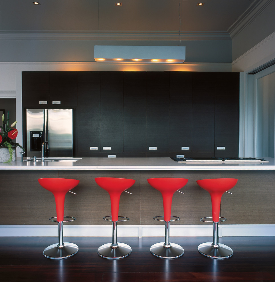 オークランドにあるコンテンポラリースタイルのおしゃれなII型キッチン (シルバーの調理設備、フラットパネル扉のキャビネット、黒いキャビネット) の写真