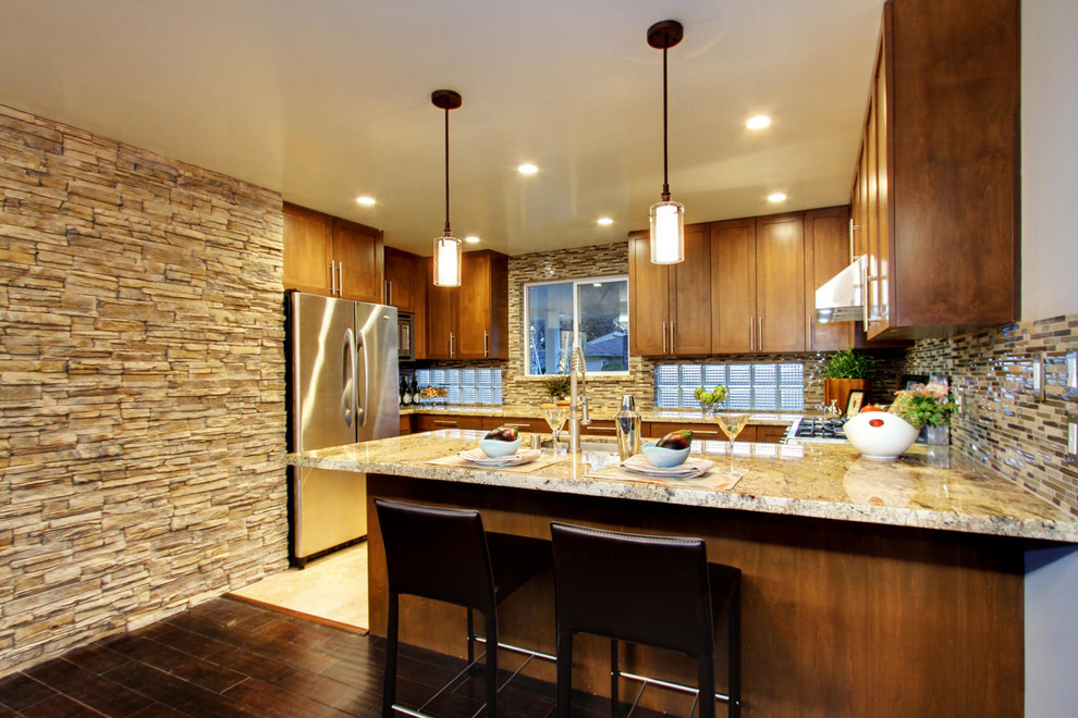 Example of a trendy u-shaped eat-in kitchen design in Sacramento with an undermount sink, shaker cabinets, light wood cabinets, granite countertops, brown backsplash and stainless steel appliances