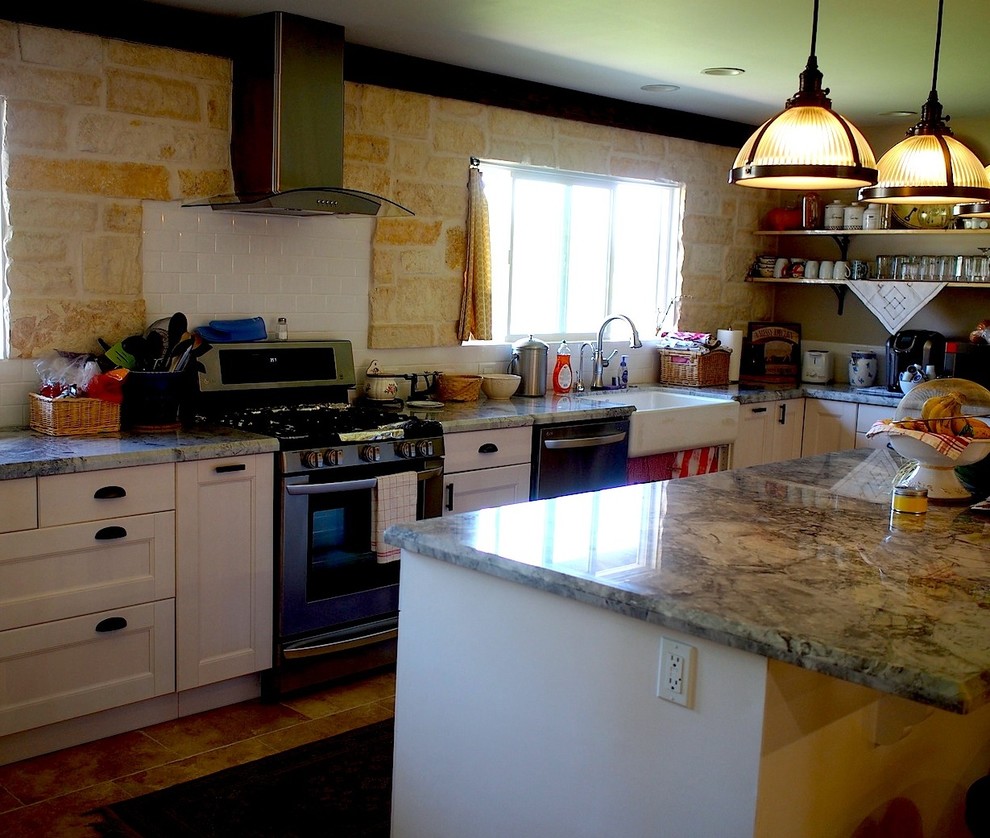 Photo of a traditional l-shaped kitchen in Los Angeles with beige splashback, stone tiled splashback and an island.