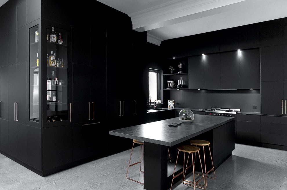 На фото: большая отдельная, параллельная кухня в стиле лофт с плоскими фасадами, черными фасадами, столешницей из бетона, островом и серой столешницей