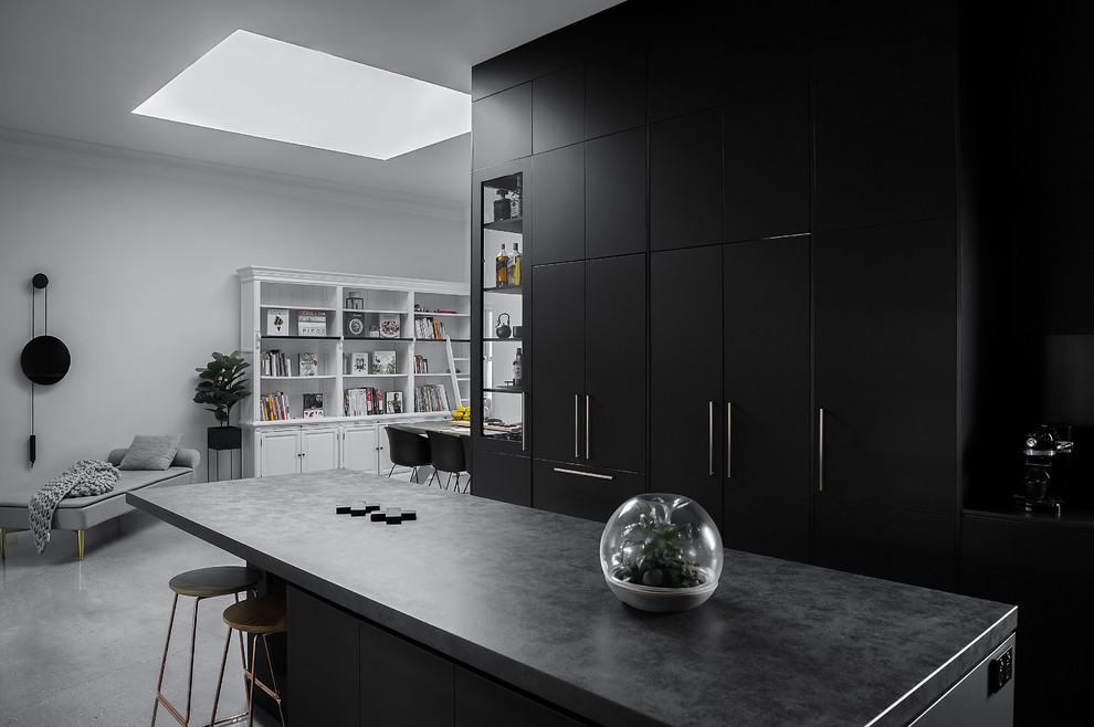 This is an example of a large urban galley enclosed kitchen in Hobart with flat-panel cabinets, black cabinets, concrete worktops, an island and grey worktops.