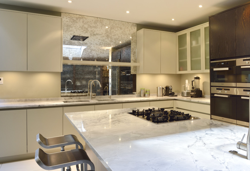 Inspiration for a large contemporary open plan kitchen in London with a built-in sink, grey cabinets, marble worktops, stainless steel appliances and porcelain flooring.