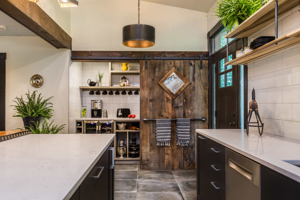 Kitchen pantry - large industrial l-shaped cement tile floor and gray floor kitchen pantry idea in Manchester with an undermount sink, flat-panel cabinets, black cabinets, quartz countertops, white backsplash, porcelain backsplash, stainless steel appliances, an island and white countertops