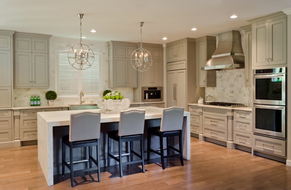 Inspiration for a contemporary l-shaped medium tone wood floor open concept kitchen remodel in Austin with a farmhouse sink, paneled appliances, an island, recessed-panel cabinets, gray cabinets, marble countertops, white backsplash and stone tile backsplash