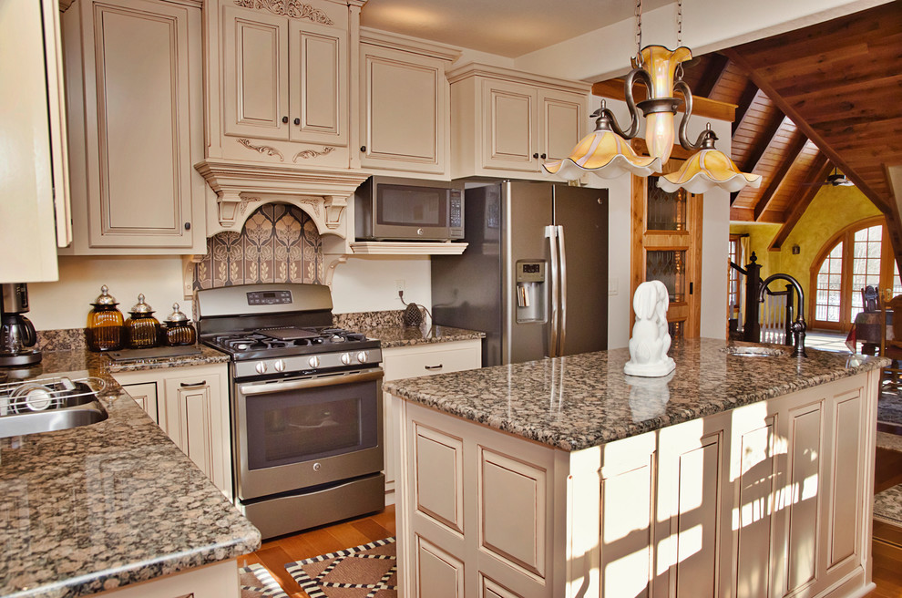 Photo of a medium sized traditional l-shaped kitchen/diner in Other with a submerged sink, raised-panel cabinets, beige cabinets, granite worktops, stainless steel appliances, medium hardwood flooring, an island and brown floors.