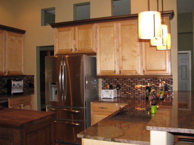 Large transitional u-shaped eat-in kitchen photo in Denver with an island, raised-panel cabinets, medium tone wood cabinets, granite countertops, red backsplash, mosaic tile backsplash and stainless steel appliances