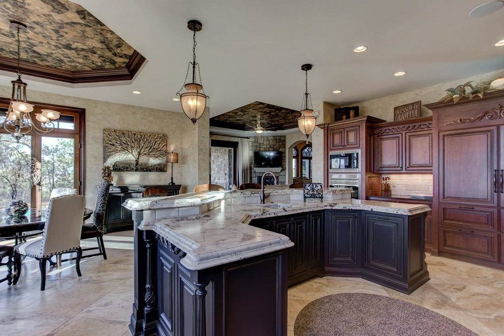 Bild på ett stort medelhavsstil flerfärgad flerfärgat kök, med en undermonterad diskho, luckor med upphöjd panel, skåp i mörkt trä, granitbänkskiva, beige stänkskydd, stänkskydd i stenkakel, integrerade vitvaror, klinkergolv i keramik, en köksö och beiget golv