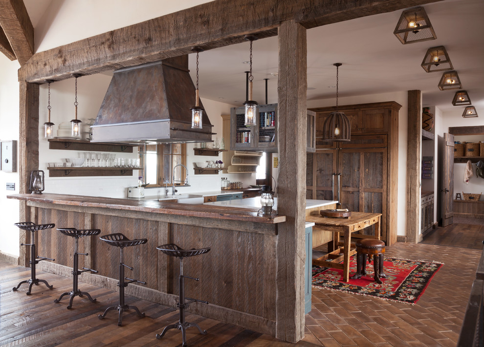 Inspiration for a large country u-shaped eat-in kitchen remodel in Denver with a farmhouse sink, shaker cabinets, distressed cabinets, white backsplash, ceramic backsplash and an island