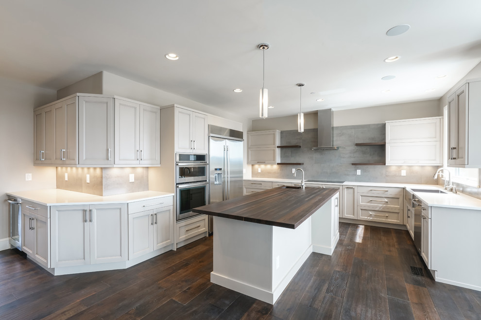 Large transitional kitchen photo in Denver with a farmhouse sink, recessed-panel cabinets, gray cabinets, stainless steel appliances and an island