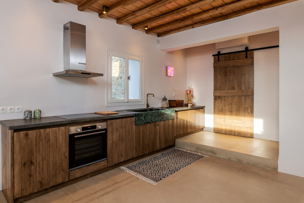Foto di una cucina lineare mediterranea con lavello stile country, ante lisce, ante in legno scuro, nessuna isola, pavimento beige, top grigio, travi a vista e soffitto in legno