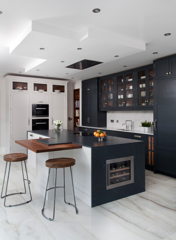 Idéer för ett modernt l-kök, med skåp i shakerstil, bänkskiva i kvartsit, en köksö, en undermonterad diskho, svarta skåp, vitt stänkskydd och vitt golv