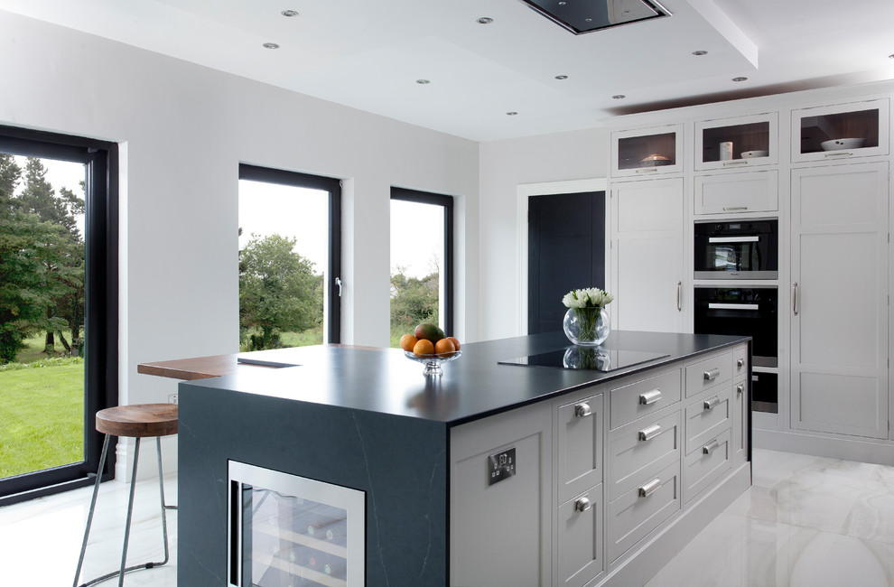 Moderne Wohnküche in L-Form mit Schrankfronten im Shaker-Stil, grauen Schränken, Quarzit-Arbeitsplatte und Kücheninsel in Sonstige