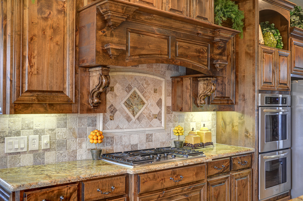 Inspiration for a large rustic single-wall kitchen in Austin with raised-panel cabinets, distressed cabinets, granite worktops, stone tiled splashback, stainless steel appliances and porcelain flooring.