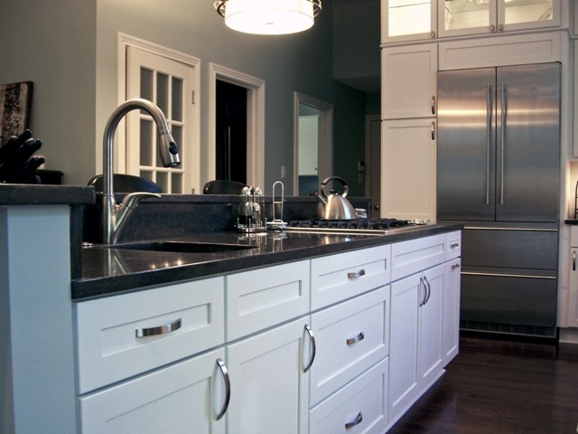 Exempel på ett klassiskt kök, med en undermonterad diskho, luckor med infälld panel, vita skåp, granitbänkskiva och rostfria vitvaror