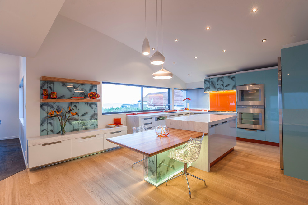 Свежая идея для дизайна: глянцевая кухня в современном стиле с плоскими фасадами, синими фасадами и оранжевым фартуком - отличное фото интерьера