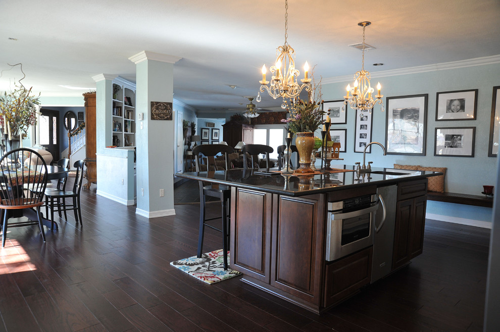 ダラスにあるトラディショナルスタイルのおしゃれなキッチン (レイズドパネル扉のキャビネット、濃色木目調キャビネット、濃色無垢フローリング、茶色い床) の写真