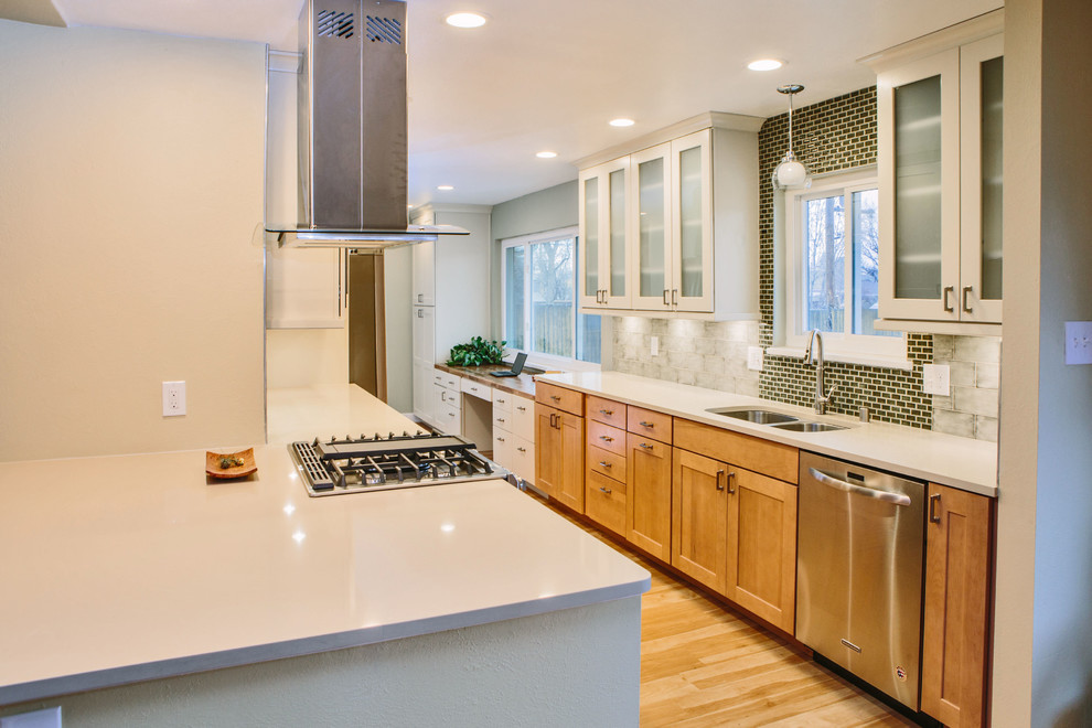 Large traditional galley kitchen/diner in Denver with a submerged sink, shaker cabinets, light wood cabinets, engineered stone countertops, green splashback, ceramic splashback, stainless steel appliances, laminate floors and a breakfast bar.