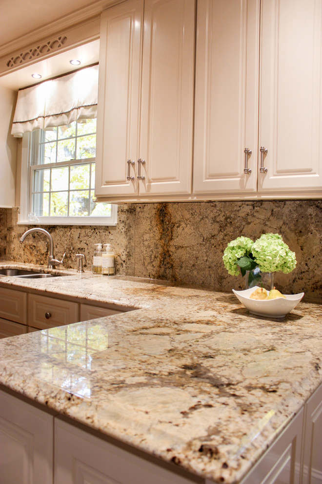 Esempio di una cucina abitabile minimal di medie dimensioni con lavello a doppia vasca, ante con bugna sagomata, ante bianche, top in granito, paraspruzzi beige e paraspruzzi in granito