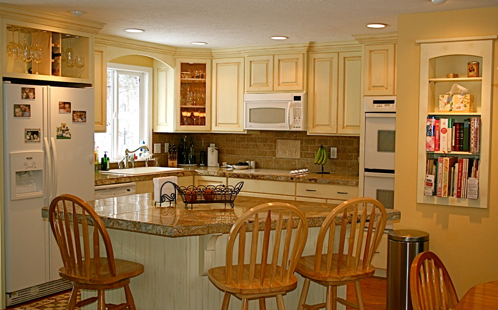 Foto de cocina comedor clásica con armarios con paneles con relieve y una isla