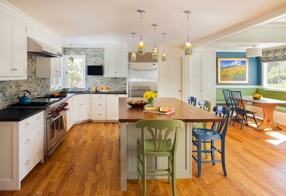 Mid-sized trendy l-shaped medium tone wood floor eat-in kitchen photo in Boston with a single-bowl sink, shaker cabinets, white cabinets, multicolored backsplash, stainless steel appliances and an island