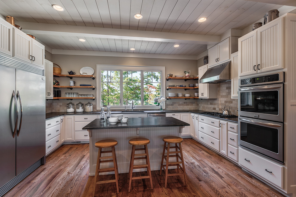 Inspiration for a large craftsman u-shaped medium tone wood floor open concept kitchen remodel in Other with an undermount sink, beaded inset cabinets, white cabinets, granite countertops, multicolored backsplash, cement tile backsplash, stainless steel appliances and an island
