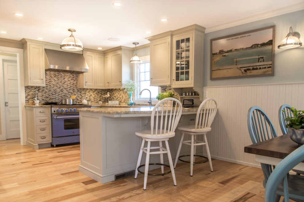 Inspiration for a small country u-shaped light wood floor and brown floor enclosed kitchen remodel in Boston with an undermount sink, beaded inset cabinets, beige cabinets, granite countertops, multicolored backsplash, glass sheet backsplash, colored appliances, a peninsula and beige countertops