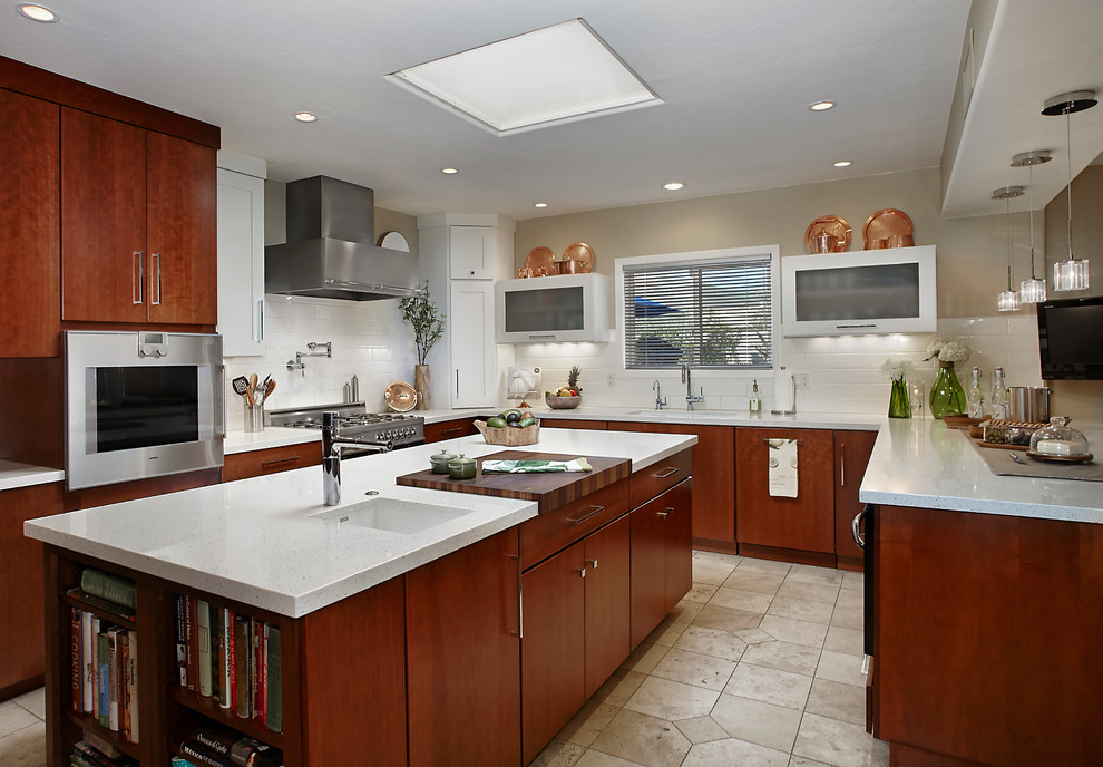 Photo of a modern u-shaped kitchen/diner in Phoenix with a submerged sink, flat-panel cabinets, medium wood cabinets, engineered stone countertops, white splashback, porcelain splashback, stainless steel appliances, porcelain flooring and an island.