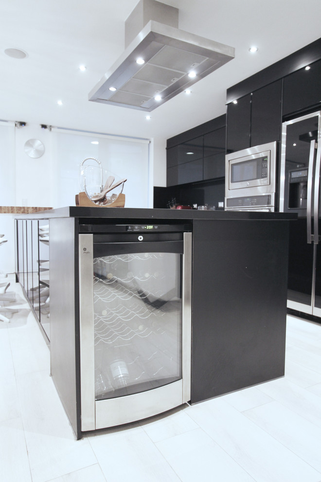 Idee per una cucina minimalista con ante di vetro, ante nere, top in quarzo composito e paraspruzzi nero