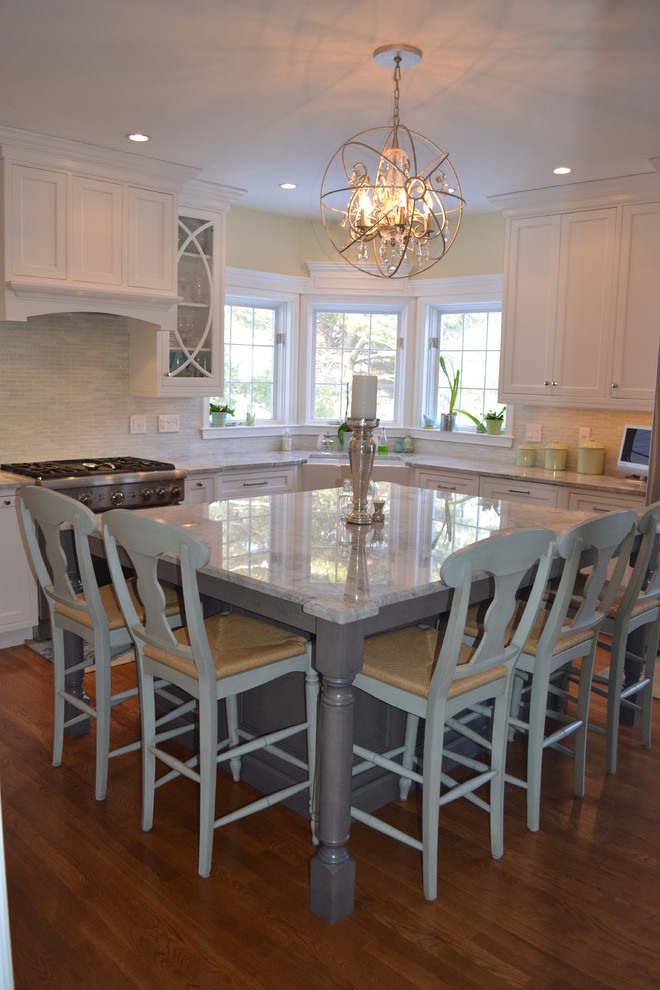 Inspiration for a large timeless l-shaped medium tone wood floor eat-in kitchen remodel in Boston with a farmhouse sink, recessed-panel cabinets, white cabinets, granite countertops, green backsplash, glass tile backsplash, stainless steel appliances and an island