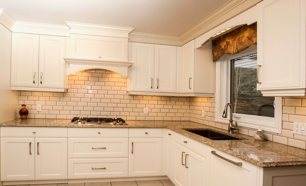 Enclosed kitchen - mid-sized traditional l-shaped ceramic tile enclosed kitchen idea in Toronto with an undermount sink, flat-panel cabinets, white cabinets, quartz countertops, beige backsplash, ceramic backsplash, paneled appliances and a peninsula
