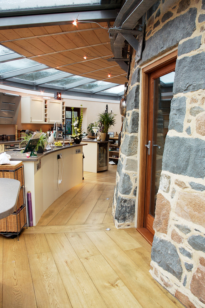 Inspiration pour une cuisine ouverte traditionnelle en U de taille moyenne avec un placard à porte shaker, des portes de placard blanches, un plan de travail en granite, un sol en bois brun et îlot.